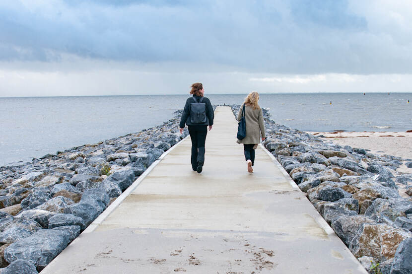 Twee vrouwen lopen richting zee